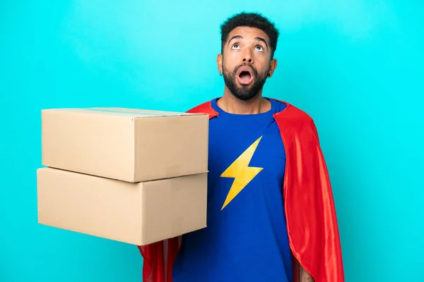 Super Hero Delivery Brazilian Man Isolated Blue Background Looking Surprised — Stock Photo, Image