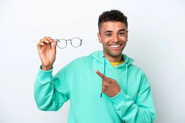 白い背景に眼鏡をかけ それを指している若いブラジル人男性 — ストック写真