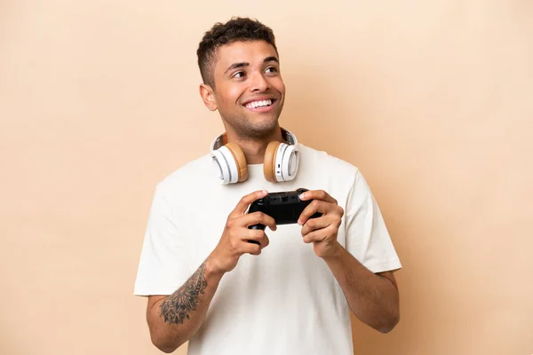 Young Brazilian Man Playing Video Game Controller Isolated Beige Background — Stock Photo, Image