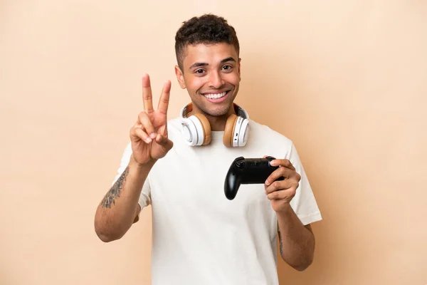 Young Brazilian Man Playing Video Game Controller Isolated Beige Background — Stockfoto