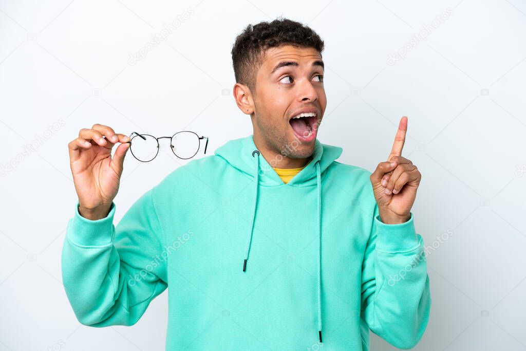 Young Brazilian man with glasses isolated on white background intending to realizes the solution while lifting a finger up