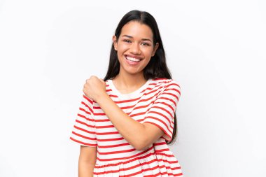 Genç Kolombiyalı kadın beyaz arka planda izole bir şekilde zaferi kutluyor.