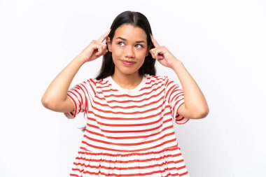 Genç Kolombiyalı kadın beyaz arka planda izole edilmiş. Şüpheleri ve düşünceleri var.