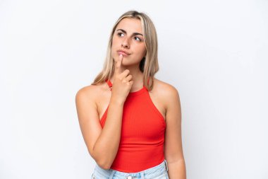 Beyaz arka planda izole edilmiş genç beyaz kadın yukarı bakarken şüpheleri var.