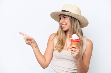 Young caucasian woman with a cornet ice cream isolated on white background pointing to the side to present a product
