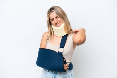 Kırık kollu ve askı takan bir kadın beyaz arka planda izole edilmiş, omuz ağrısından muzdarip, çabaladığı için.