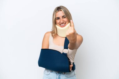 Kırık kollu ve askı takan bir kadın beyaz arka planda izole edilmiş bir şekilde geliyor.