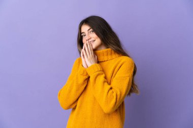 Mor arka planda izole edilmiş genç beyaz kadın avuç içlerini bir arada tutuyor. İnsan bir şey ister.