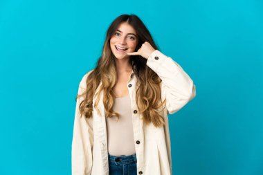 Mavi arka planda izole edilmiş beyaz bir kadın telefon jesti yapıyor. Bana geri dönüş işareti ver.