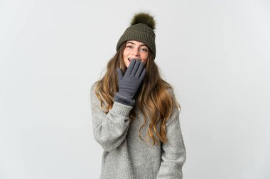 Beyaz arka planda izole edilmiş beyaz şapkalı beyaz bir kadın mutlu ve ağzı kapalı gülümsüyor.