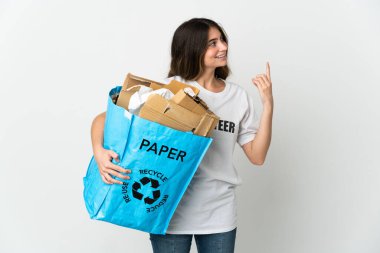 Young woman holding a recycling bag full of paper to recycle isolated on white background pointing up a great idea