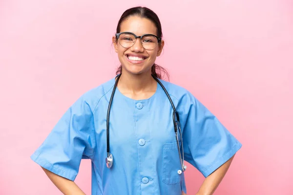 年轻的哥伦比亚护士 身披粉红背景 双手叉腰 面带微笑 与人隔离 — 图库照片
