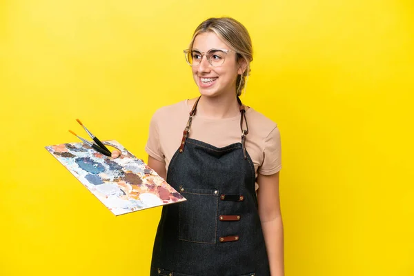 Młody Artysta Kaukaski Kobieta Trzyma Paleta Odizolowany Żółty Tło Patrząc — Zdjęcie stockowe