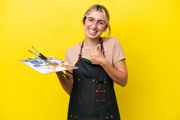 Młody Artysta Kaukaski Kobieta Trzyma Paleta Odizolowany Żółty Tło Dając — Zdjęcie stockowe