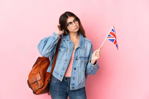 Молодая Женщина Держащая Флаг Великобритании Изолированы Розовом Фоне Имеющие Сомнения — стоковое фото