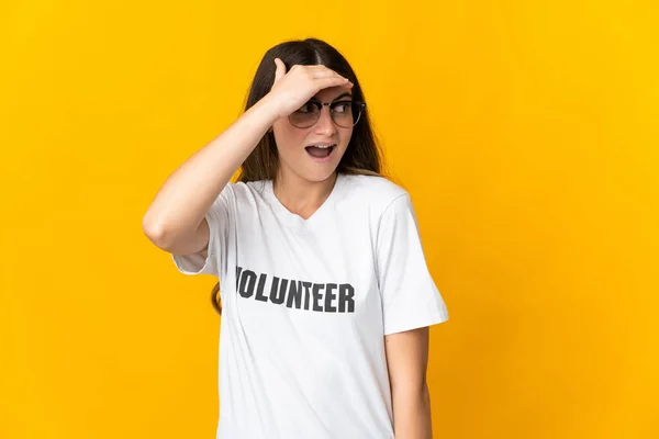 Joven Voluntaria Aislada Sobre Fondo Amarillo Haciendo Gesto Sorpresa Mientras — Foto de Stock