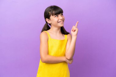 Mor arka planda izole edilmiş beyaz çocuk harika bir fikre işaret ediyor.