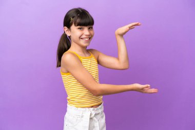 Mor arka planda izole edilmiş beyaz bir çocuk ilan vermek için kopyalama alanı tutuyor.