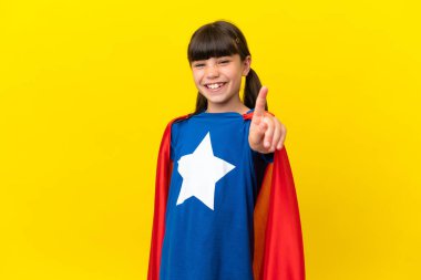 Mor arka planda izole edilmiş küçük süper kahraman çocuk parmağını kaldırıp kaldırıyor.