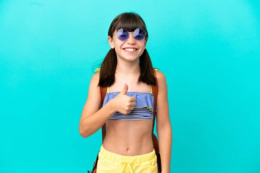 Küçük beyaz bir çocuk mavi arka planda izole bir şekilde sahile gidiyor.