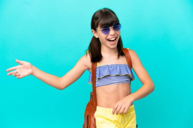 Küçük beyaz bir çocuk kumsala gidiyor. Mavi arka planda izole edilmiş. Gitar jesti yapıyor.