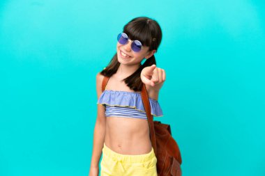 Mavi arka planda izole bir şekilde sahile giden küçük beyaz çocuk kendine güvenen bir ifadeyle seni işaret ediyor.