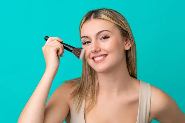 Mulher Caucasiana Jovem Isolado Fundo Azul Segurando Escova Maquiagem — Fotografia de Stock