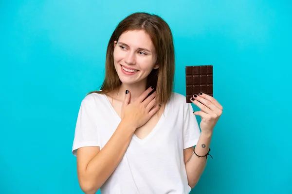 Mladá Anglická Žena Čokoládou Izolované Modrém Pozadí Vzhlíží Usmívá — Stock fotografie