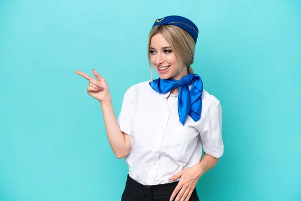 Samolot Blondynka Stewardessa Kobieta Izolowana Niebieskim Tle Wskazując Palcem Bok — Zdjęcie stockowe
