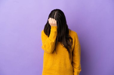 Mor arka planda başağrısı olan genç beyaz bir kadın.