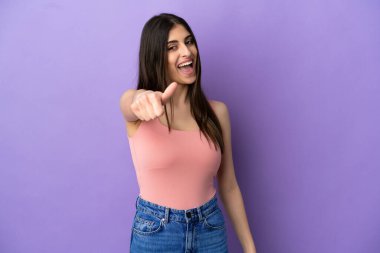 Genç beyaz kadın mor arka planda izole edildi. Başparmakları havada çünkü iyi bir şey oldu.