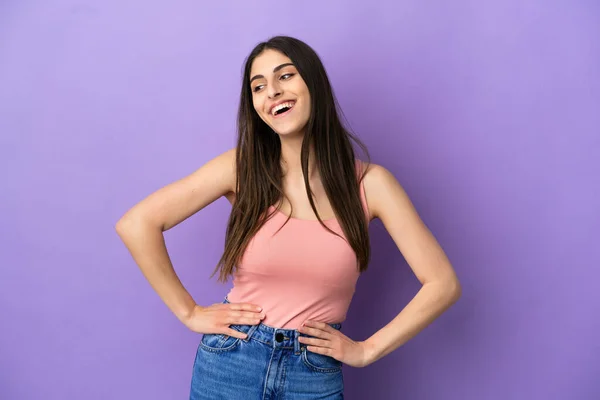 Young Caucasian Woman Isolated Purple Background Posing Arms Hip Smiling — Stock Photo, Image
