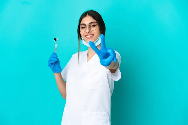 Νεαρή Καυκάσια Οδοντίατρος Κρατώντας Εργαλεία Απομονωμένα Μπλε Φόντο Χαμογελώντας Και — Φωτογραφία Αρχείου