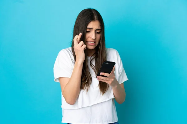 Junge Kaukasische Frau Isoliert Auf Blauem Hintergrund Mit Handy Mit — Stockfoto