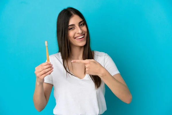 Młoda Biała Kobieta Myje Zęby Wyizolowane Niebieskim Tle Wskazuje — Zdjęcie stockowe