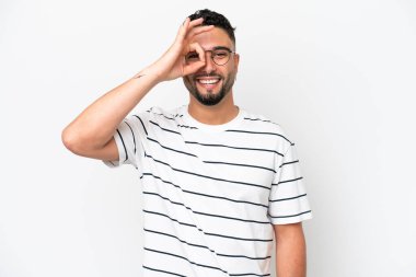 Beyaz arka planda izole edilmiş genç Arap yakışıklı adam parmaklarıyla işaret veriyor.