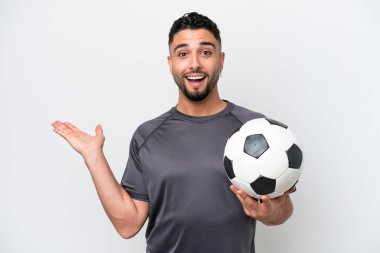 Arap futbolcu genç adam, beyaz arka planda şok olmuş yüz ifadesiyle izole edilmiş.