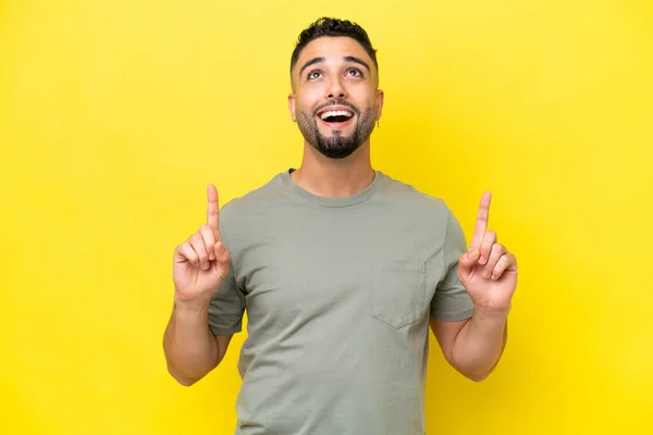 Mladý Arab Hezký Muž Izolovaný Žlutém Pozadí Překvapen Ukazuje Nahoru — Stock fotografie