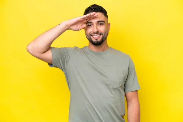 Young Arab Handsome Man Isolated Yellow Background Saluting Hand Happy — Stockfoto