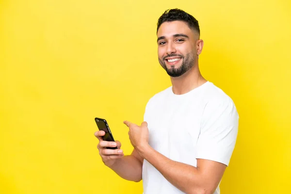 Joven Árabe Guapo Hombre Aislado Sobre Fondo Amarillo Usando Teléfono —  Fotos de Stock