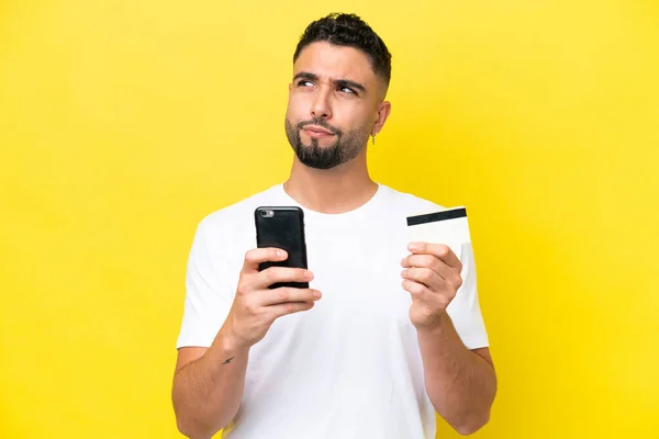 Young Arab Handsome Man Isolated Yellow Background Buying Mobile Credit — 스톡 사진