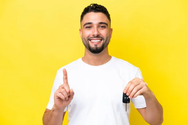 Mladý Arab Muž Drží Klíče Auta Izolované Žlutém Pozadí Ukazuje — Stock fotografie