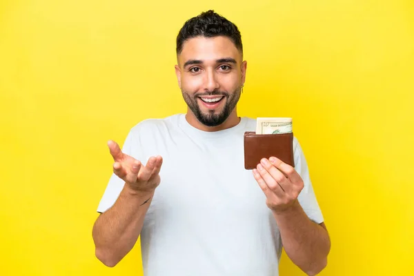 Mladý Arab Muž Drží Peněženku Izolované Žlutém Pozadí Šokovaným Výrazem — Stock fotografie