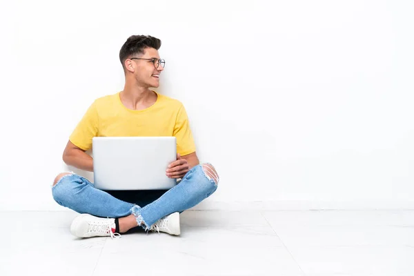 Giovane Seduto Sul Pavimento Isolato Sfondo Bianco Guardando Lato — Foto Stock