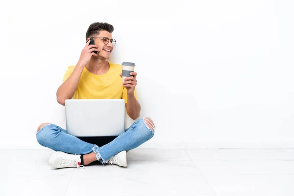 Jovem Sentado Chão Isolado Fundo Branco Segurando Café Para Levar — Fotografia de Stock