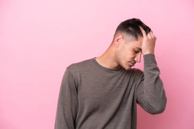 Kafkasyalı genç adam pembe arka planda izole edilmiş, baş ağrısı var.