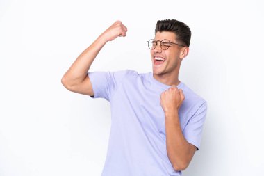 Beyaz arka planda izole edilmiş genç beyaz adam zaferi kutluyor.