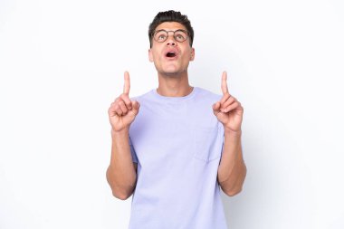 Beyaz arka planda izole edilmiş genç beyaz adam şaşırmış ve yukarı bakıyor.