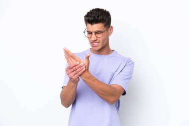 Beyaz arka planda izole edilmiş genç beyaz bir adam ellerinde acıdan muzdarip.