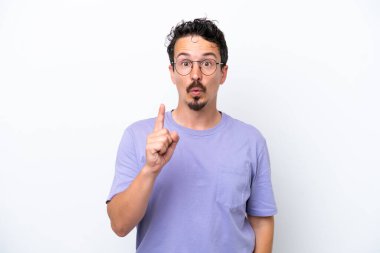 Bıyıklı genç adam beyaz arka planda izole edilmiş bir şekilde parmağını kaldırarak çözümü bulmaya çalışıyor.